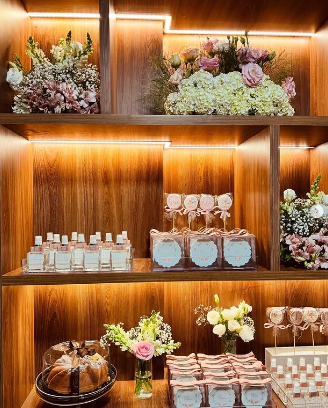 Prateleiras com arranjos em tons de rosa e mesa posta